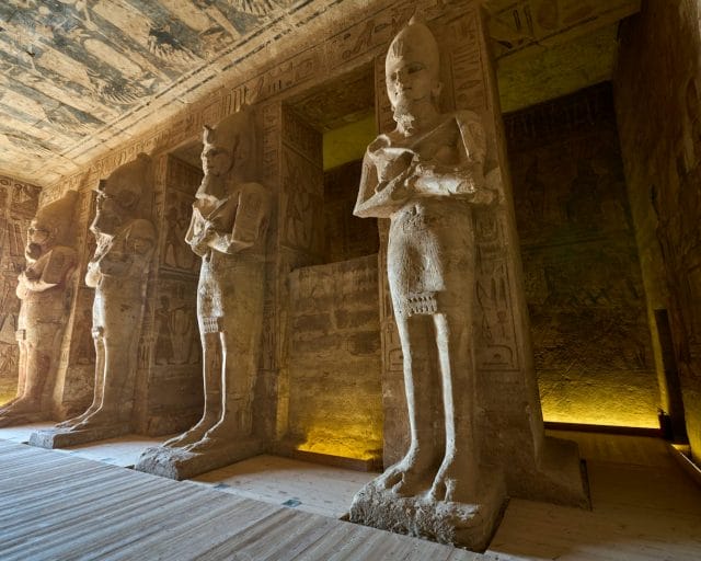 a group of statues in a room next to a wall